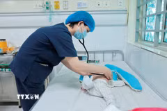 Bác sỹ khám cho bệnh nhi hơn 2 tháng tuổi mắc ho gà điều trị tại Trung tâm bệnh Nhiệt đới (Bệnh viện Nhi Trung ương). (Ảnh: Minh Quyết/TTXVN)