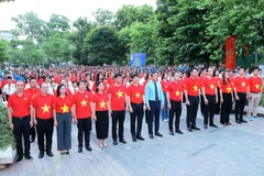 Các đại biểu và thanh niên, đoàn viên thực hiện nghi lễ chào cờ. (Ảnh: An Đăng/TTXVN)