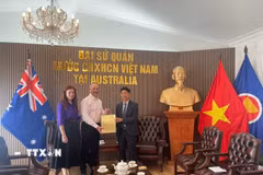 Vợ chồng ông Glenn Mathews trao lại cuốn nhật ký của liệt sĩ Võ Văn Công cho đại diện Đại sứ quán Việt Nam tại Australia - Tham tán Công sứ Nghiêm Xuân Hoà. (Ảnh: TTXVN phát)