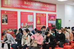 Người dân xếp hàng trật tự theo lượt chờ đến lượt giao dịch trong ngày vía Thần Tài tại cửa hàng vàng trên phố Cầu Giấy. (Ảnh: Lê Đông/TTXVN)