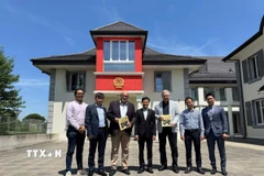 Công sứ Cung Đức Hân - Phó Trưởng Phái đoàn Việt Nam, cùng cán bộ phái đoàn với các nhà báo Thụy Sĩ và Việt Nam. (Ảnh: TTXVN phát)
