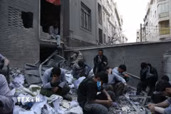 Người dân ngồi trên đống đổ nát của những tòa nhà bị phá hủy do xung đột tại Tehran, Iran ngày 15/3/2026. (Ảnh: THX/TTXVN)