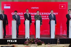 Thượng tướng Hoàng Xuân Chiến (thứ 3 phải sang), Ủy viên Thường vụ Quân ủy Trung ương, Thứ trưởng Bộ Quốc phòng cùng các đại biểu bấm nút khai trương Văn phòng Đại diện Viettel tại Singapore. (Ảnh: Việt Dũng/TTXVN)