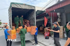 Các thùng mỳ tôm được vận chuyển lên xe ủng hộ người dân vùng lũ miền Trung. (Ảnh: Tiến Vĩnh/TTXVN)