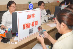 Người dân quét mã QR để tra cứu thủ tục và quy trình hồ sơ thuộc lĩnh vực tư pháp - hộ tịch. (Ảnh: Hữu Duyên/TTXVN)