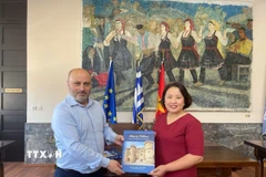 Phó Thị trưởng đảo Rhodes Chalkias Konstantinos tặng sách cho Đại sứ Phạm Thị Thu Hương. (Ảnh: TTXVN phát)