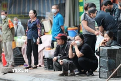 Gương mặt thất thần của người dân khi chứng kiến khu kinh doanh bị thiêu rụi. (Ảnh: Lê Đông/TTXVN)