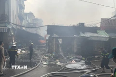 Các tổ công tác tiếp tục triển khai dập tàn và làm mát các cấu kiện để phòng ngừa cháy bùng phát trở lại. (Ảnh: Quốc Lũy/TTXVN)