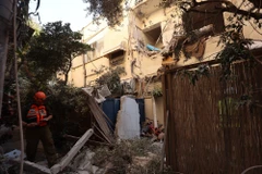 Lực lượng cứu hộ làm nhiệm vụ tại hiện trường vụ không kích của Iran xuống Tel Aviv, Israel. (Ảnh: THX/TTXVN)