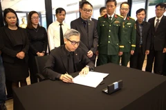 Đại sứ Việt Nam tại Nhà nước Israel Lý Đức Trung ghi sổ tang tưởng nhớ nguyên Chủ tịch nước Trần Đức Lương. (Ảnh: Phạm Hà/TTXVN)\