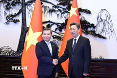 Chánh án Tòa án nhân dân tối cao Việt Nam Lê Minh Trí chào xã giao Bí thư Ủy ban chính pháp Trung ương Đảng Cộng sản Trung Quốc Trần Văn Thanh. (Ảnh: Quang Hưng/TTXVN)