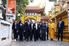Thủ tướng Phạm Minh Chính và Phu nhân cùng Thủ tướng Ethiopia Abiy Ahmed Ali và Phu nhân nghe giới thiệu về văn hóa, lịch sử, kiến trúc chùa Trấn Quốc. (Ảnh: Dương Giang/TTXVN)