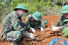 Hài cốt liệt sỹ được phát hiện ở độ sâu 1m với nhiều di vật kèm theo. (Ảnh: TTXVN phát)