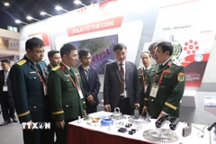 Thiếu tướng Nguyễn Bá Lực (ngoài cùng, bên phải), Phó Tổng tham mưu trưởng Quân đội nhân dân Việt Nam thăm gian hàng của Viettel Manufacturing tại triển lãm. (Ảnh: Đỗ Sinh/TTXVN)