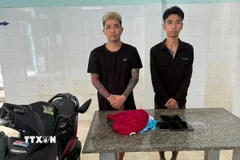 Hai đối tượng Lương Công Thuận và Lê Văn Nhâm tại cơ quan công an. (Ảnh: TTXVN phát)