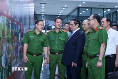 Thủ tướng Phạm Minh Chính xem hình ảnh về công tác giám định ADN hài cốt liệt sỹ. (Ảnh: Dương Giang/TTXVN)