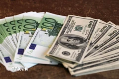 Đồng tiền giấy mệnh giá 100 euro (trái) và 100 USD tại Paris (Pháp). (Ảnh: )AFP/TTXVN