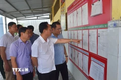 Ông Phạm Văn Thiều (áo trắng), Phó Bí thư Tỉnh ủy, Chủ tịch HĐND tỉnh Cà Mau tra công tác bầu cử tại Khu vực bỏ phiếu số 21, thuộc Ban bầu cử số 7, ấp Giồng Bướm A, xã Châu Thới. (Ảnh: Chanh Đa/TTXVN)