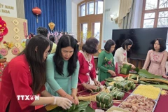 Các phu nhân cán bộ, nhân viên Đại sứ quán và các cơ quan bên cạnh Đại sứ quán tại Nga tham gia gói bánh chưng. (Ảnh: Trần Hải/TTXVN)