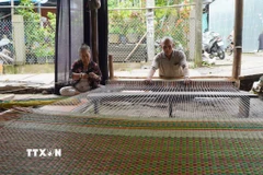Gia đình ông Huỳnh Văn Chiến là một trong số ít hộ dân ở làng chiếu Định Yên còn dệt chiếu thủ công để giới thiệu nghề truyền thống với khách du lịch. (Ảnh: Nhựt AnTTXVN)