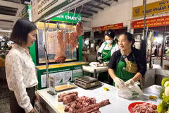 Đại diện phường Tân Mỹ trò chuyện với tiểu thương tham gia bán thịt "Tick xanh trách nhiệm" tại chợ Tân Mỹ, Thành phố Hồ Chí Minh. (Ảnh: Hương Giang/TTXVN)