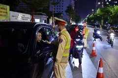 Cán bộ, chiến sĩ đội CSGT số 6 kiểm tra nồng độ cồn với các tài xế tại tuyến phố Trần Thái Tông - Tôn Thất Thuyết. (Ảnh: Phạm Kiên/TTXVN)
