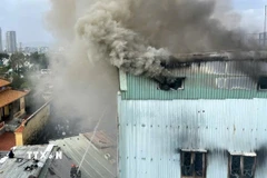 Cảnh sát phòng cháy, chữa cháy và cứu nạn, cứu hộ nỗ lực khống chế đám cháy. (Ảnh: Quốc Dũng/TTXVN)