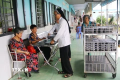 Phát cơm cho người được chăm sóc tại Cơ sở Bảo trợ xã hội dưỡng lão tình thương Suối Tiên (Đồng Nai). (Ảnh: Lê Xuân/TTXVN)