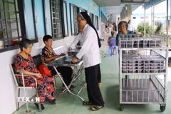 Phát cơm cho người được chăm sóc tại Cơ sở Bảo trợ xã hội dưỡng lão tình thương Suối Tiên (Đồng Nai). (Ảnh: Lê Xuân/TTXVN)