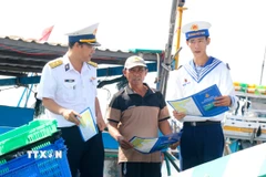 Cán bộ, chiến sỹ Lữ đoàn 681, Vùng 2 Hải quân, tuyên truyền cho ngư dân về phòng chống vi phạm khai thác hải sản bất hợp pháp, không báo cáo và không theo quy định (IUU). (Ảnh: Nguyễn Thanh/TTXVN)