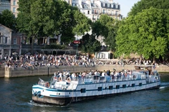 Người dân tránh nóng tại sông Seine ở Paris, Pháp. (Ảnh: THX/TTXVN)