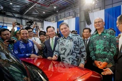 Ông Airlangga Hartarto - Bộ trưởng Điều phối kinh tế Indonesia (thứ 2 từ phải), ký tặng lên xe điện VF 3 trong lễ khánh thành. (Ảnh: VinFast)