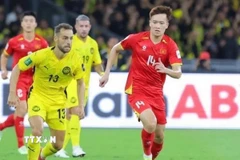 Nỗ lực đi bóng của Hoàng Đức (14-tuyển Việt Nam) trước các cầu thủ Malaysia. (Ảnh: TTXVN phát)
