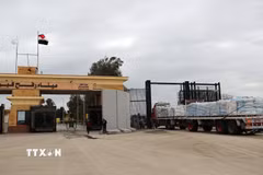 Xe chở hàng viện trợ nhân đạo đi qua cửa khẩu Rafah. (Ảnh: THX/TTXVN)