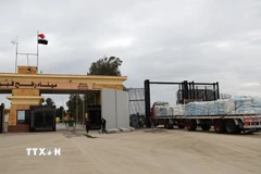 Xe chở hàng viện trợ nhân đạo đi qua cửa khẩu Rafah. (Ảnh: THX/TTXVN)
