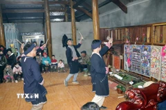 Trong ảnh: Thầy cúng và chủ nhà làm lễ trước ban thờ tổ tiên. (Ảnh: Hữu Quyết/TTXVN)