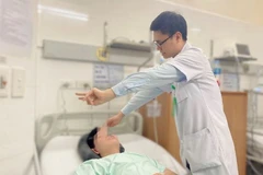 Bác sỹ Lê Quốc Việt, Khoa Nội-Hồi sức thần kinh, thăm khám cho bệnh nhân sau phẫu thuật. (Ảnh: Bệnh viện cung cấp)