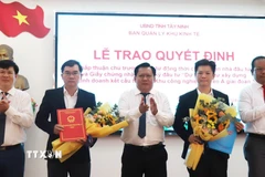 Phó Chủ tịch Ủy ban Nhân dân tỉnh Tây Ninh Huỳnh Văn Sơn trao Quyết định chấp thuận chủ trương đầu tư dự án Khu công nghiệp Xuyên Á giai đoạn 3. (Ảnh: Thanh Bình/TTXVN)