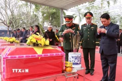 Lãnh đạo tỉnh Tuyên Quang cùng thân nhân các liệt sỹ dâng hương các phần mộ được an táng tại nghĩa trang liệt sỹ Vị Xuyên (Tuyên Quang). (Ảnh: Đức Thọ/TTXVN)