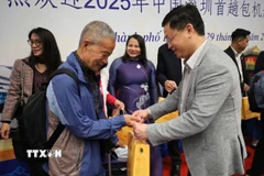 Các hành khách trên chuyến bay DZ6355 được lãnh đạo thành phố Huế trao hoa và tặng quà lưu niệm chúc mừng. (Ảnh: Văn Dũng/TTXVN)