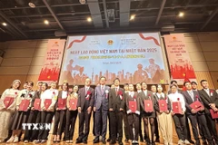 Đại sứ Phạm Quang Hiệu, đại diện Bộ Tư pháp Nhật Bản và đại diện Bộ Y tế, Lao động và Phúc lợi Nhật Bản cùng với cho 26 lao động, thực tập sinh ưu tú Việt Nam chụp ảnh lưu niệm. (Ảnh: Nguyễn Tuyến/TTXVN)