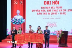 Phó Thủ tướng Lê Thành Long và Bộ trưởng Bộ Văn hoá-Thể thao và Du lịch Nguyễn Văn Hùng trao cờ thi đua của Chính phủ cho các đơn vị đạt thành tích xuất sắc. (Ảnh: Hoàng Hiếu/TTXVN)
