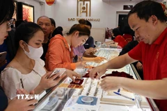 Mua bán vàng tại một cửa hàng kinh doanh vàng. (Ảnh: Trần Việt/TTXVN)