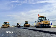 Thi công thảm bê tông nhựa trên tuyến chính cao tốc đoạn qua địa bàn phường Vĩnh Tế, tỉnh An Giang. (Ảnh: Thanh Sang/TTXVN)