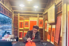 Ông đồ cho chữ tại Hội chữ Xuân Bính Ngọ 2026 trong không gian Hồ Văn, di tích quốc gia đặc biệt Văn Miếu-Quốc Tử Giám. (Ảnh: Tuyết Mai/TTXVN)