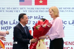 Ông Phạm Thành Kiên tặng hoa chúc mừng bà Susan Burns, Tổng lãnh sự Hoa Kỳ tại Thành phố Hồ Chí Minh. (Ảnh: Xuân Khu/TTXVN)