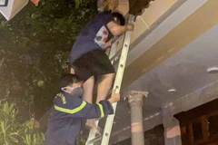 Người bị nạn được lực lượng chức năng hỗ trợ thoát khỏi ngôi nhà qua thang. (Ảnh: Công an cung cấp)