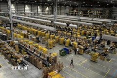 Nhân viên đóng gói hàng hóa cho khách hàng tại một trung tâm dịch vụ của Amazon. (Ảnh: AFP/ TTXVN)
