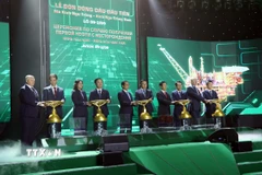 Các đại biểu thực hiện nghi thức mở van đón dòng dầu đầu tiên. (Ảnh: Đoàn Mạnh Dương/TTXVN)