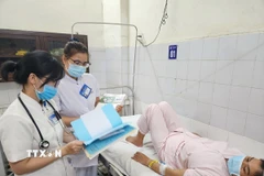 Bác sỹ, điều dưỡng Khoa Bệnh nhiệt đới, Bệnh viện Trung ương Huế kiểm tra, theo dõi sức khỏe bệnh nhân mắc liên cầu lợn. (Ảnh: Mai Trang/TTXVN)